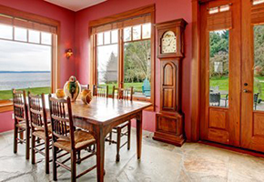 Wooden kitchen table and large wooden grandfather clock in pink painted room